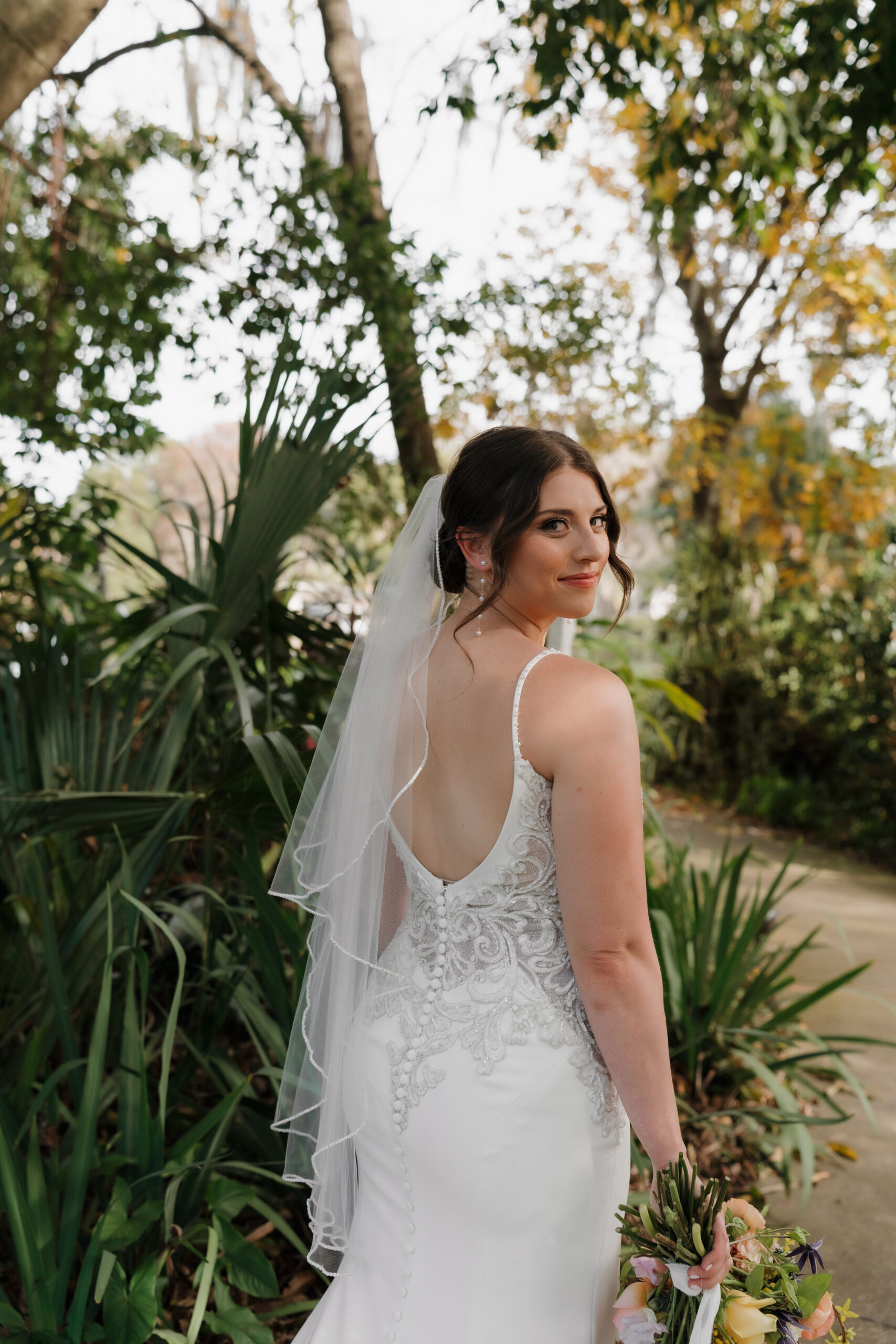 Hair and makeup in Orlando | Makeup Artist Orlando Beauty Brigade | Bride with a low back gown and veil with an effortless updo