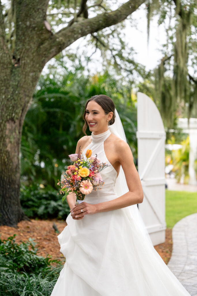 Bridal makeup and hair Orlando | Makeup Artist Orlando Beauty Brigade | Bride with a styled updo holding a bouquet