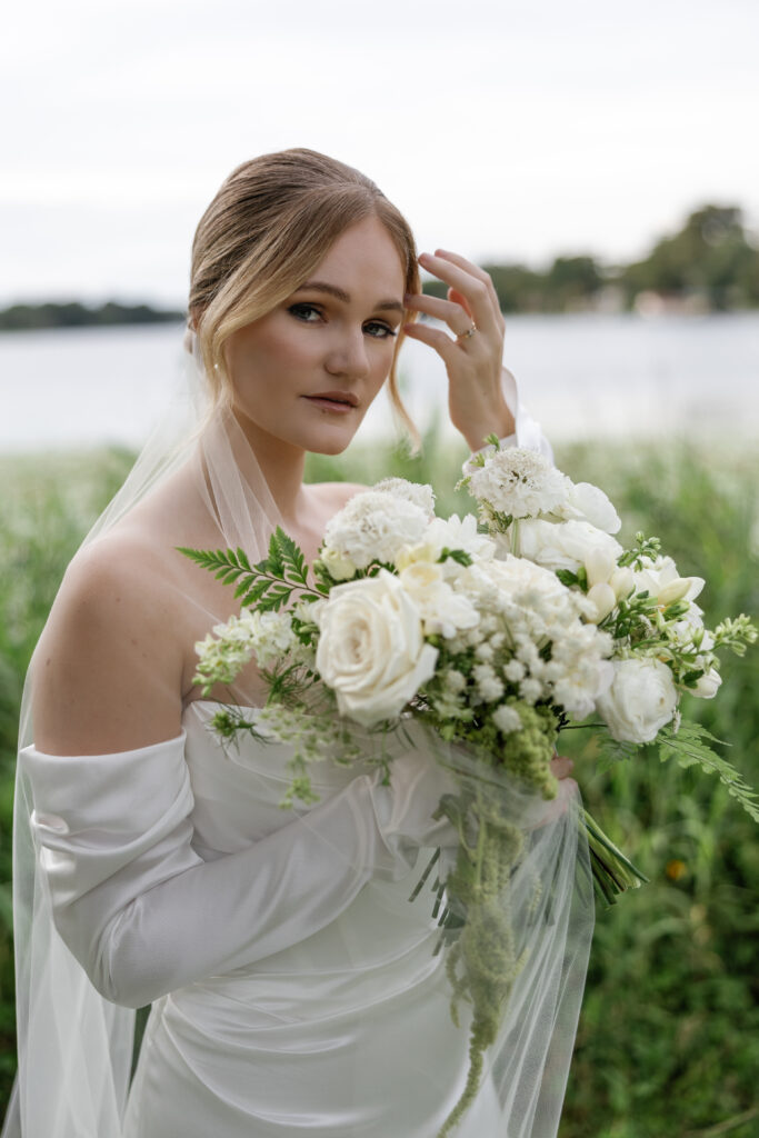 Wedding makeup artist in Orlando | Makeup Artist Orlando Beauty Brigade | Bride with soft glam makeup and styled updo holding a bouquet