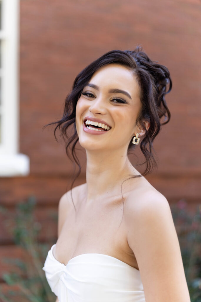 Orlando wedding hair and makeup | Makeup Artist Orlando Beauty Brigade | Bride with styled curls in an updo laughing