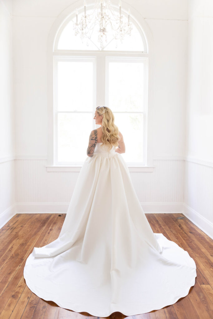 Tampa hair and makeup | Makeup Artist Orlando Beauty Brigade | Bride with soft curls standing by the window